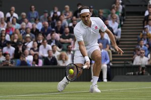 Switzerland's Roger Federer plays a return to Poland's Hubert Hurkacz during the men's singles quarterfinals match on day nine of the Wimbledon Tennis Championships in London, Wednesday, July 7, 2021