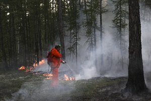 Firefighters and volunteers work at the scene of forest fire near Magan village in Yakutsk region, republic of Sakha also known as Yakutia, Russia Far East, on Tuesday, Aug. 10, 2021