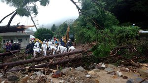 In this photo provided by Nagasaki Kenou Wide Area Fire Department, rescuers work at a mudslide site following heavy rain in Obama, Unzen city, Nagasaki Prefecture, Saturday, Aug. 14, 2021