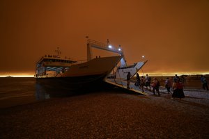 People use a ferry to evacuate from Pefki village on Evia island, about 189 kilometers (118 miles) north of Athens, Greece, Sunday, Aug. 8, 2021