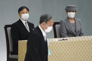 Japan's Emperor Naruhito and Empress Masako watch Japanese Prime Minister Yoshihide Suga walk by after delivering a speech during a ceremony to mark the 76th anniversary of Japan's surrender in World War II at Budokan hall in Tokyo Sunday, Aug. 15, 2021