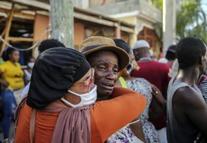 People cry during the search for disappeared in a house destroyed by the earthquake in Les Cayes, Haiti, Sunday, Aug. 15, 2021