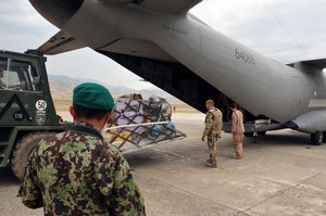 KABUL, Afghanistan -- German members of the International Security Assistance Force and Airmen from the 438th Air Expeditionary Advisory Group, unload a C-27 Spartan transport aircraft loaded with humanitarian aid at the international airport of Feyzabad, Afghanistan