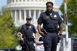 U.S. Capitol Police officers stand at an intersection near the U.S. Capitol and a Library of Congress building in Washington on Thursday, Aug. 19, 2021