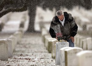 FILE - In this Feb. 28, 2005, file photo, Johnny Spann, father of slain CIA officer Mike Spann of Alabama, who was the first American to die in Afghanistan, pauses at his son's gravesite at Arlington National Cemetery in Arlington, Va.