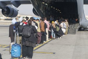 HAMID KARZAI INTERNATIONAL AIRPORT, Afghanistan (August 18, 2021) – Evacuees stage before boarding a C-17 Globemaster III during an evacuation at Hamid Karzai International Airport, Afghanistan, Aug. 18