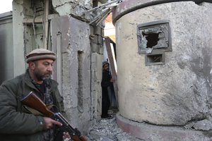 An Afghan security stands guard at the gate of Spanish embassy, after a terrorist attack to the Spanish embassy, in the centre of Kabul, Afghanistan, Saturday, Dec. 12, 2015. Explosions and gunfire rocked a diplomatic area of central Kabul overnight as security forces tried to flush out Taliban attackers who claimed responsibility for a deadly car bomb Friday. Spain said one of its police officers was killed in the bombing. Hours later, the U.N. Security Council issued a condemnation that said an Afghan policeman had been killed as well. Seven civilians were wounded. (AP Photo/Rahmat Gul)