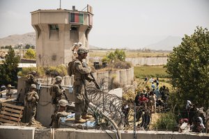 In this image provided by the U.S. Marine Corps, Marines assist with security at an evacuation control checkpoint during an evacuation at Hamid Karzai International Airport in Kabul, Afghanistan, Friday, Aug. 20, 2021