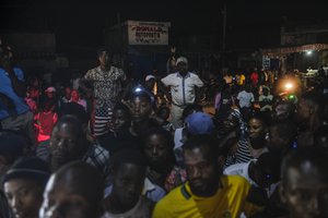 People watch as Mexican firefighters known as "Los Topos" work during a rescue attempt in Les Cayes, Haiti, Friday, Aug. 20, 2021, six days after a 7.2 magnitude earthquake hit the area