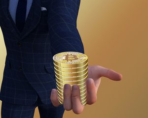 Business man holds paper with pile of Bitcoins