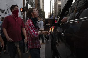 A Black Lives Matter protester yells at a supporter of President Donald Trump during a rally and car parade Saturday, Aug. 29, 2020