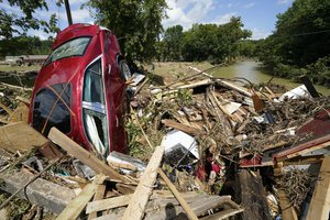 A car is among debris that washed up against a bridge over a stream Sunday, Aug. 22, 2021, in Waverly, Tenn.