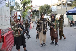 Taliban fighters stand guard at a checkpoint on the road in Kabul, Afghanistan, Wednesday, Aug. 25, 2021