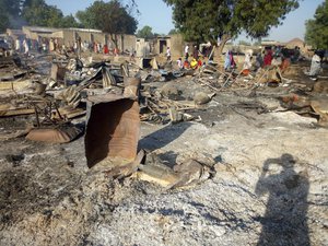 File - People gather at the site of an attack in Maiduguri, Nigeria, Thursday, Nov. 1, 2018, after dozens of suspected Boko Haram attackers overpowered soldiers guarding the camp and fighting continued for about two hours.