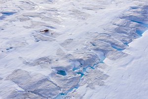 In this Aug. 16, 2019, photo, a helicopter carrying New York University air and ocean scientist David Holland and his team sits on the ice as they install a radar and GPS at the Helheim glacier, in Greenland.