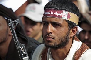 A supporter of Yemen's Shiite Houthi rebels, wearing a bandana with with an Arabic inscription reading, "On your Service Hussein", as he attends the holy day of Ashoura, in Sanaa, Yemen, Thursday, Aug. 19, 2021