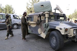 Taliban fighters stand guard at a checkpoint near the gate of Hamid Karzai international Airport in Kabul, Afghanistan, Saturday, Aug. 28, 2021