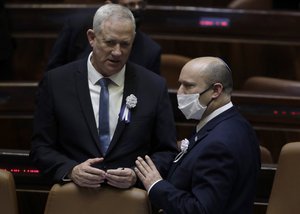 Israel's prime minister Naftali Bennett, right, speaks with Israel's Minister of Defense Benny Gantz, after Israel's President-elect Isaac Herzog sworn in ceremony in the Knesset in Jerusalem, Wednesday, July 7, 2021