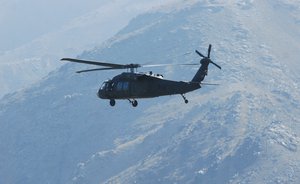 A UH-60L Blackhawk helicopter crewed by 1st Lt. Chuck Nadd, Chief Warrant Officer 4 Darren Dreher, Staff Sgt. Bruce Kleckner and Sgt. Jay Herring, all members of Task Force Phoenix, flies over Kabul province, Afghanistan, while conducting a personnel movement mission, Sept. 4, 2013