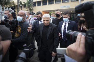 Yesh Atid party leader Yair Lapid leaves after he voted for Israel's parliamentary election at a polling station in Tel Aviv, Israel, Tuesday, March. 23, 2021.