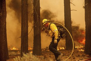 A firefighter battles the Caldor Fire along Highway 89, Tuesday, Aug. 31, 2021, near South Lake Tahoe