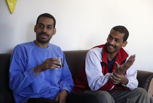 In this March 30, 2018, file photo, Alexanda Amon Kotey, left, and El Shafee Elsheikh, who were allegedly among four British jihadis who made up a brutal Islamic State cell dubbed "The Beatles," speak during an interview with The Associated Press at a security center in Kobani, Syria