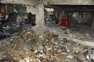 In this photo released by the Syrian official news agency SANA, Syrian officials check the damage of a building targeted by Israeli missile strikes in the early morning in the Mezzeh area in the capital Damascus, Syria, Tuesday, Nov. 12, 2019.