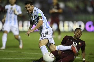 Argentina's Lionel Messi, left, and Venezuela's Jose Martinez battle for the ball during a qualifying soccer match for the FIFA World Cup Qatar 2022 in Caracas, Venezuela, Thursday, Sept. 2, 2021