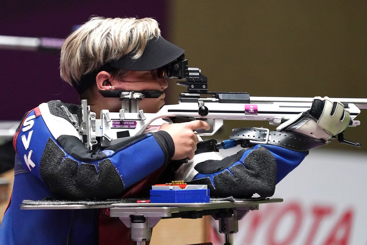 Vadovicova in action in the shooting. She is sat up, leaning her arms on a platform and holding the gun close to her face as she looks in the viewfinder. 