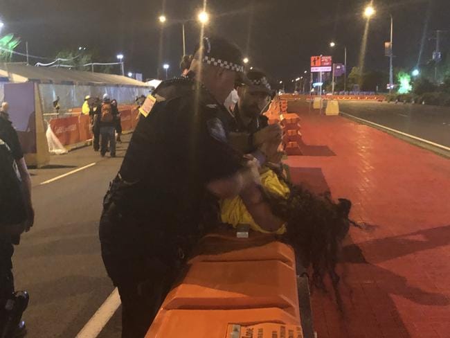 Demonstrators were held down after allegedly trying to storm the Gold Coast stadium after a day of peaceful protests turned ugly, with scuffles breaking out. Picture: Britt Ramsey