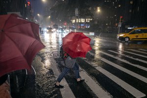 Pedestrians take cover near Columbus Circle in New York Wednesday, Sept. 1, 2021, as the remnants of Hurricane Ida remained powerful while moving along the Eastern seaboard