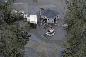 An oil slick drifts near a home in slowly receding floodwaters in the aftermath of Hurricane Ida in Lafitte, La., Wednesday, Sept. 1, 2021.