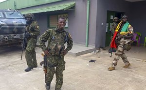 In this image made from video, unidentified soldiers patrol near the office of the president in the capital Conakry, Guinea Sunday, Sept. 5, 2021