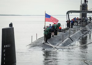 File - Sailors aboard the Virginia-class fast-attack submarine USS John Warner (SSN 785) shift colors during the boat’s homecoming at Naval Station Norfolk, Nov. 25, 2020.