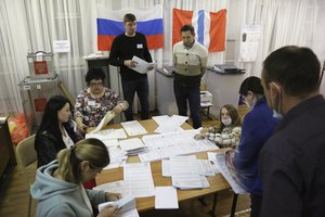 Members of an election commission count ballots after voting at a polling station after the Parliamentary elections in Nikolayevka village outside Omsk, Russia, Sunday, Sept. 19, 2021