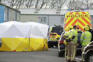 Fire officers stand inside a cordon at the vehicle recovery business "Ashley Wood Recovery" in Salisbury, England, Tuesday, March 13, 2018.