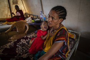 File - In this Tuesday, May 11, 2021 file photo, mother Roman Kidanemariam, 35, holds her malnourished daughter Merkab Ataklti, 22 months old, in the treatment tent of a medical clinic in the town of Abi Adi, in the Tigray region of northern Ethiopia.