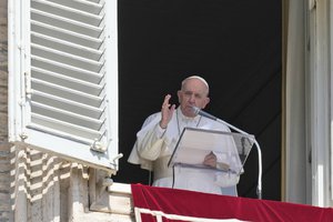 Pope Francis delivers his blessing during the Angelus noon prayer from the window of his studio overlooking St.Peter's Square, at the Vatican, Sunday, Sept. 19, 2021