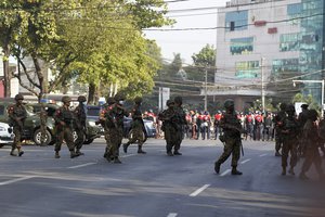 File - Soldiers cross the road near the headquarters of the National League for Democracy party in Yangon, Myanmar Monday, Feb. 15, 2021. Security forces in Myanmar intensified their crackdown against anti-coup protesters