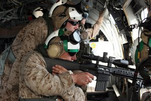 A scout sniper from Battalion Landing fires his MK-11 sniper rifle from a CH-46 Sea Knight helicopter