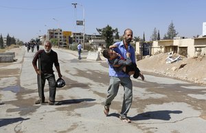 File - A disabled man is carried as civilians leave the Moadamiyeh suburb of Damascus, Syria, on Friday, Sept. 2, 2016.