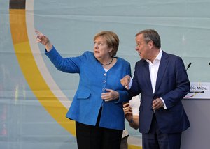 Chancellor Angela Merkel and Governor Armin Laschet, top candidate for the upcoming election, stand on the podium at the final election campaign event of the Christian Democratic Party, CDU, ahead of the German general election in Aachen, Germany, Saturday, Sept. 25, 2021.