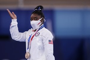 Simone Biles, of the United States, reacts after winning the bronze medal on the balance beam during the artistic gymnastics women's apparatus final at the 2020 Summer Olympics, Tuesday, Aug. 3, 2021, in Tokyo, Japan