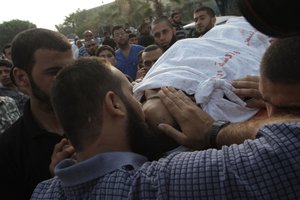 File - Palestinians mourn during the funeral of Basel Ahmed in the al-Bureij refugee camp in the central Gaza Strip on June 22, 2012 after he was killed and two were wounded, one seriously, when Israeli warplanes struck east of Al-Bureij.