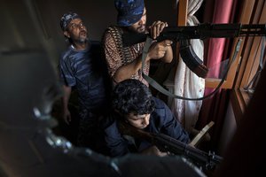 In this Aug 31, 2019 file photo, fighters of the 'Shelba' unit, a militia allied with the U.N.-supported Libyan government, aim at enemy positions at the Salah-addin neighborhood front line in Tripoli, Libya. Two Libyan militia commanders and a Syrian war monitor group say Turkey is deploying Syrian extremists to fight in Libya's civil war.