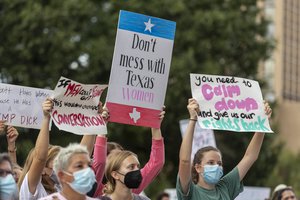 In this Oct. 2, 2021, file photo, people attend the Women's March ATX rally, at the Texas State Capitol in Austin, Texas