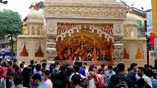 Devotees take pictures of a puja pandal ahead of the Durga puja festival, in Kolkata on Sunday. (ANI Photo)