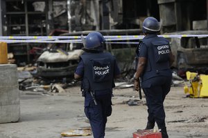 Ghanian police officers patrol the remaining structure of a gas station in Accra, Ghana, Friday, June 5, 2015.