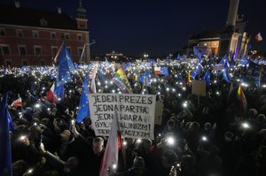 People hold up the flashlights of their mobile phones during a demonstration in support of Poland's EU membership in Warsaw, Poland, Sunday, October 10, 2021.