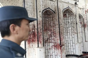 An Afghan police stands inside a damaged mosque in Kabul, Afghanistan, Saturday, Oct. 21, 2017, a day after a suicide attack.